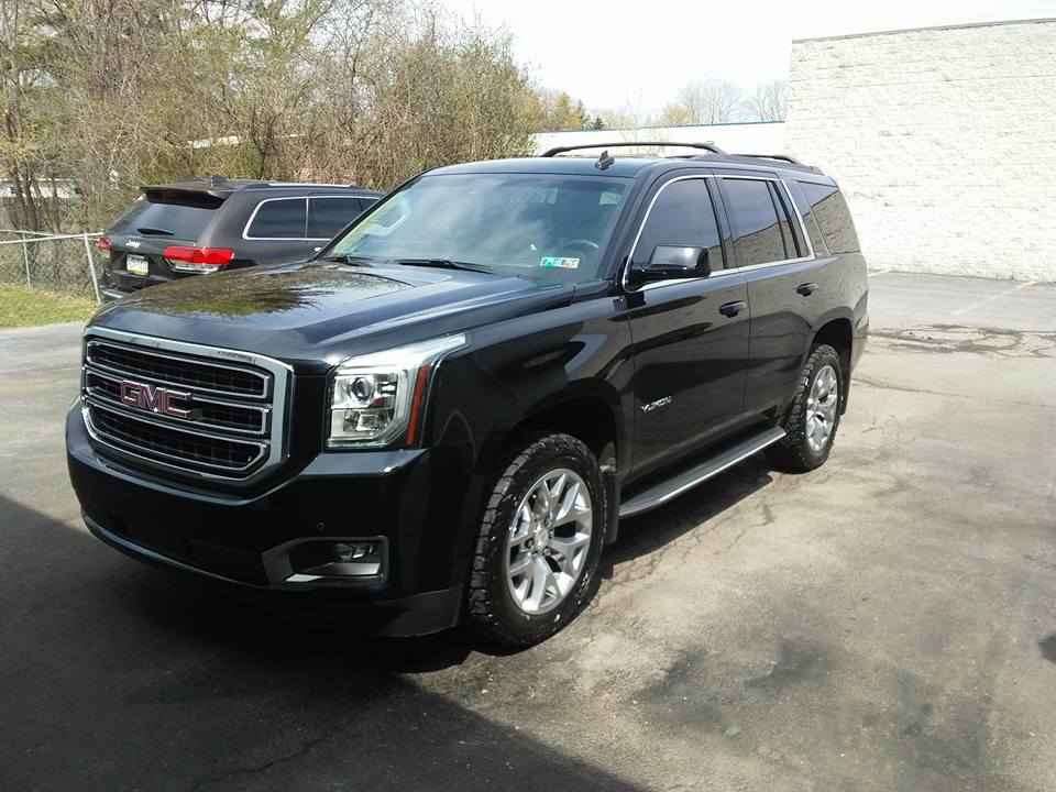 Black GMC Yukon parked outside the shop